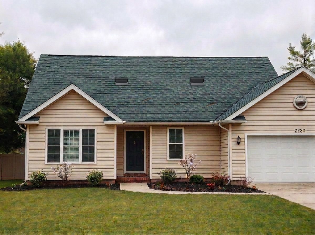 A storm-damaged roof with missing and lifted shingles, before replacement